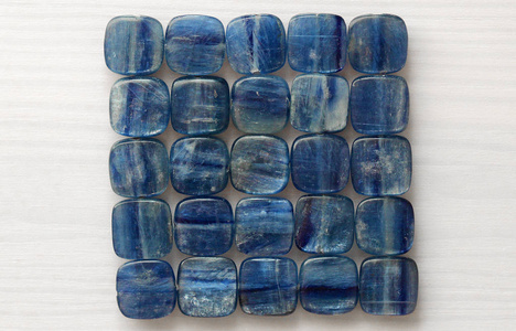 天然石 Kyanit 的照片珠子。天然矿物蓝色晶石白色木质背景