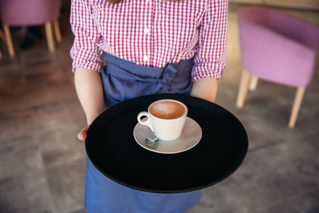 提供一杯咖啡在咖啡厅的服务员