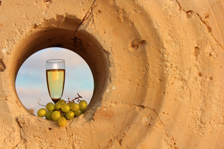 一杯白葡萄酒和一堆葡萄在国家公园 Achziv 的磨石中, 以色列