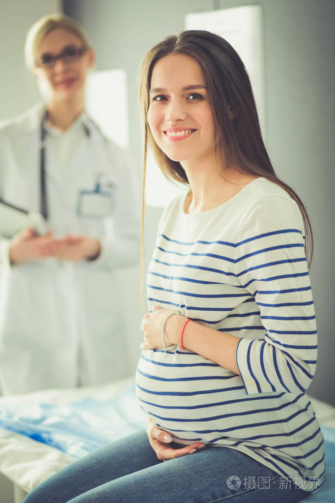 美丽的微笑孕妇在医院医生
