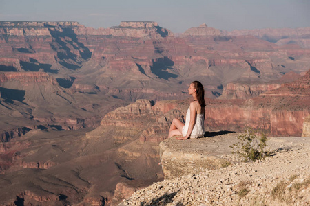 游客在大峡谷坐在岩石边缘, 亚利桑那州, 美国