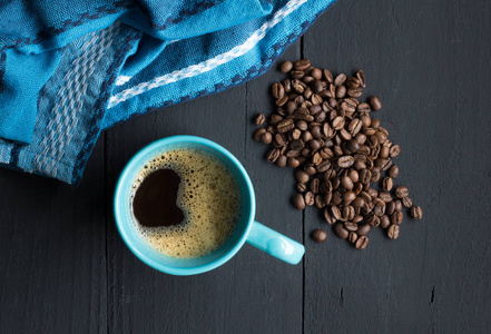 咖啡杯在质朴的黑木厨房桌与咖啡豆