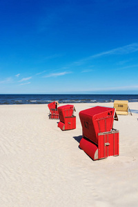 波罗的海阳光明媚的日子里的红沙滩椅