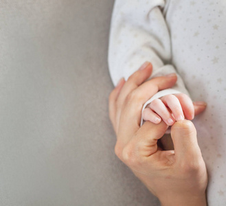 妈妈抱着新生儿的手, 亲情关爱让步