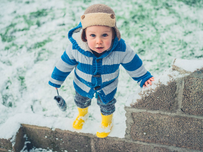 一个鳞甲的小男孩站在雪地里