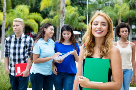 美丽的美国女学生与一群国际人在大学校园户外