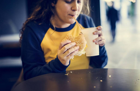 青少年女孩吃汉堡包肥胖概念的特写
