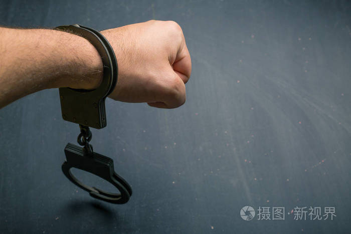 男子在黑暗背景下手铐照片-正版商用图片0uitx9-摄图新视界