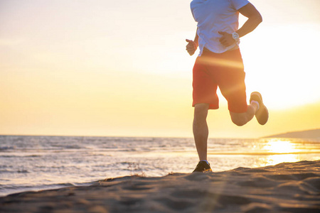 日落时分在海滩上奔跑的人的低剖面视图