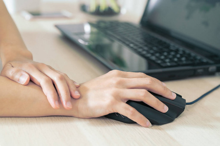 女子手腕臂痛长使用鼠标工作。办公室综合症保健与医学概念