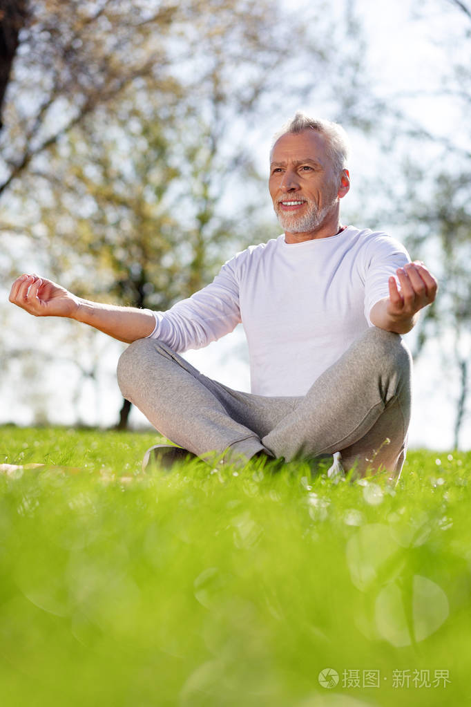 快活的老人坐在莲花姿势