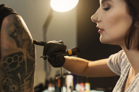 年轻女子 tattooist 在肩上做纹身