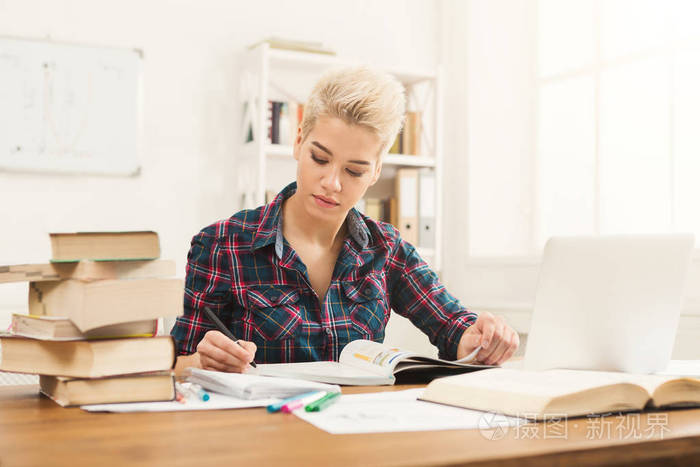 在桌上读书的学生女孩满书