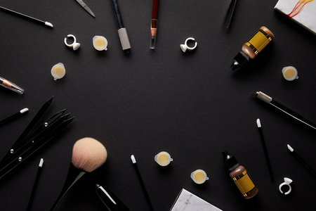 在沙龙黑色桌面上永久化妆工具的顶级视图