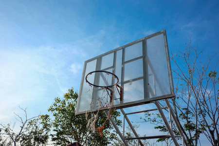 老 basketballhoop 在公园与蓝天背景