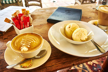 在南非葡萄园的一张木桌上的卡布奇诺拿铁和冰淇淋