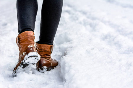 棕色靴子在雪地里, 女人在雪地里踩着台阶, 在冬天散步