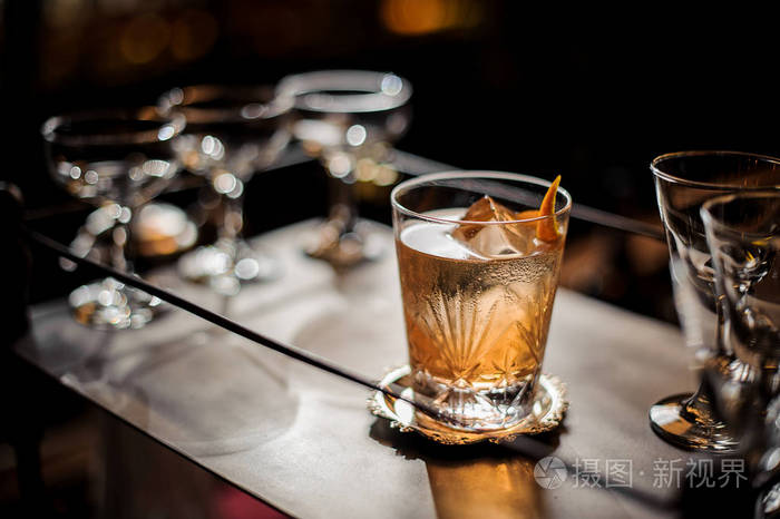 新鲜美味的酒精夏日鸡尾酒在玻璃装饰与橙色的热情站在空鸡尾酒眼镜在酒吧