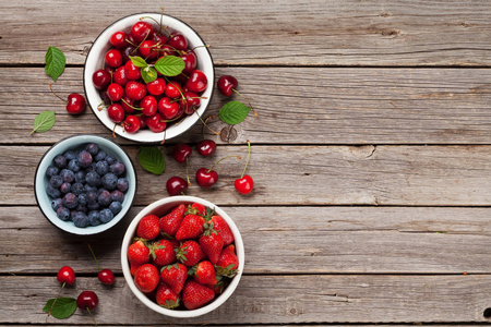 新鲜的夏日浆果。樱桃, 蓝莓和草莓在碗里。具有复制空间的顶部视图