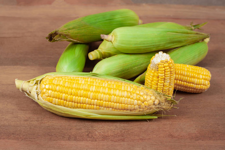 有机新鲜玉米芯或玉米耳在木材上。健康食品