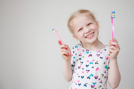 小漂亮的金发女孩手里拿着牙刷。卫生保健牙科卫生人与美容理念