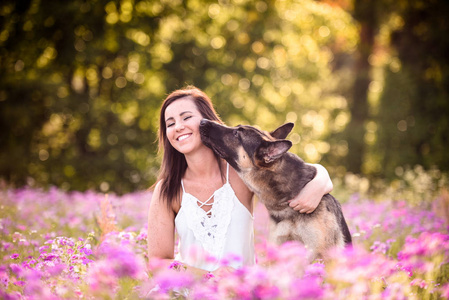 年轻妇女与德国牧羊犬在华丽的夏天领域