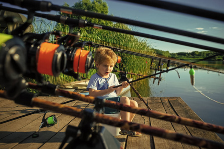 捕鱼设备。英俊的小男孩举行钓鱼竿