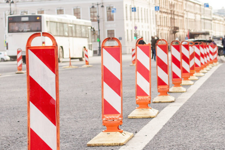 在城市的道路工作。橙色交通锥在街道的中间。交通安全建设大修标志。背景白色总线