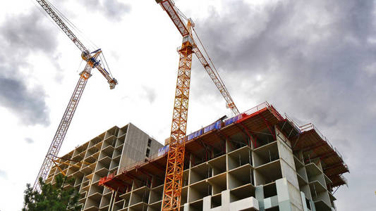 在建工程现场两座建筑起重机和建筑在建.施工现场照片