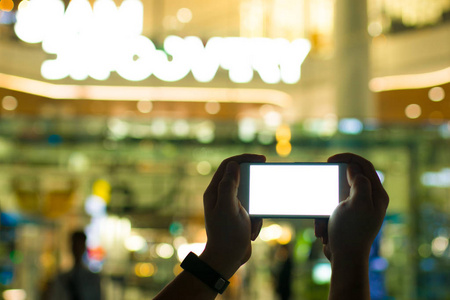 两只手的人玩智能手机与明亮的白色显示器的彩色散背景高科技的概念