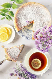 春季茶与法国糕点 萨伏地海绵蛋糕, 开花紫藤和杯柠檬茶。顶部视图, 色调图像