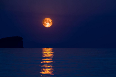 满月在海与抽象闪耀的水和小船剪影在月光反射