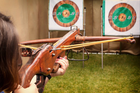 有弓箭的男孩集中在目标上.孩子盯着目标.孩子用箭头瞄准目标.