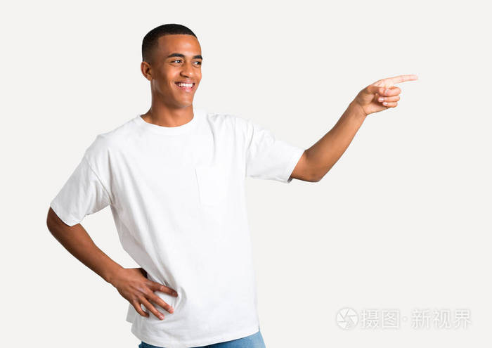 年轻的非洲裔美国人的手指指向侧面, 并提出一个产品, 而微笑着一个