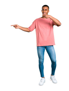站在年轻的非洲裔美国男子指着手指侧面, 并提出了一个产品, 而微笑着在孤立的白色背景