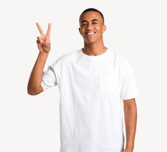 年轻的非洲裔美国人微笑和显示胜利标志在孤立的背景开朗的面孔