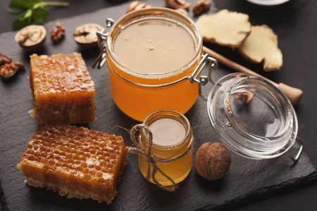 蜂蜜分类特写玻璃罐, 蜂窝, 花粉碗, 坚果, 生姜, 薄荷和干橙。甜蜜的背景墙纸自然医学概念