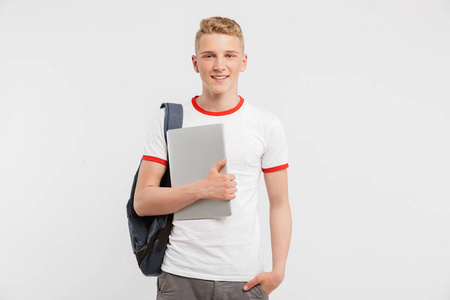 青少年男子1618 岁的形象穿着休闲服装和背包看着你手持笔记本电脑在白色背景下被隔离