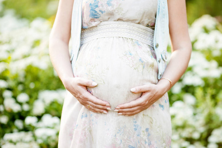 孕妇摸她的肚子，用手的特写图片
