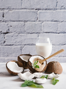 椰奶碎椰子和薄荷叶在白色桌上