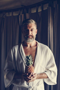 穿着浴衣的男人拿着菠萝