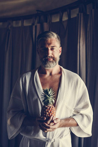 穿着浴衣的男人拿着菠萝