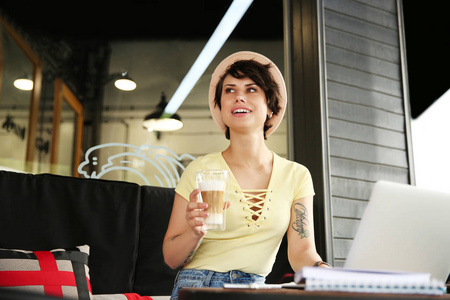 在咖啡馆工作的年轻妇女在办公桌上的笔记本电脑