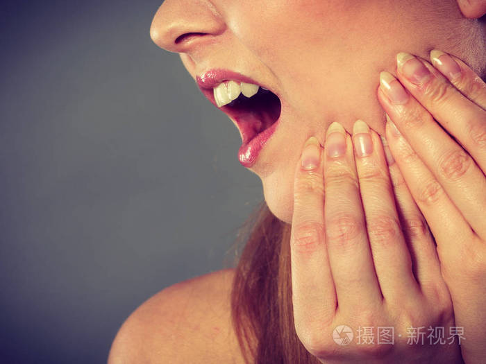 年轻女人疼女孩患可怕牙齿疼痛,触摸用手按住她的脸颊棕榈特写