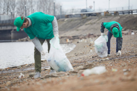 保护环境的年轻人河边捡垃圾照片