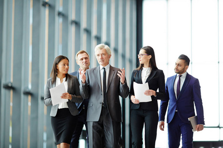 代表会议小组代表在正装听同事或领导, 当步行到会议时照片