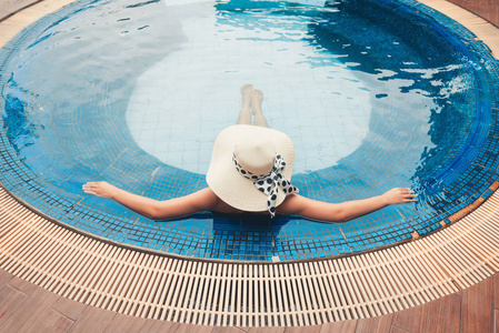 亚洲妇女在游泳池和日光浴中放松的画像