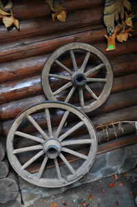 木制建筑墙上有两个轮子的车