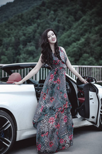 时尚的肖像年轻女子穿着优雅的衣服户外敞篷车