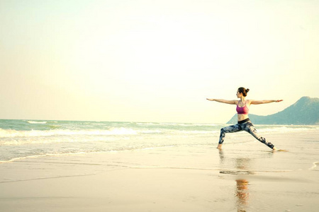 女人练瑜伽在海滩